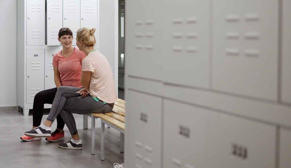 Women discussing aqua aerobics in locker room