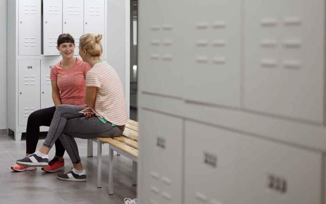 Women discussing aqua aerobics in locker room