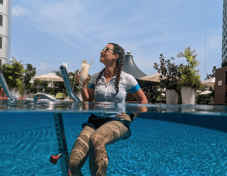 Women in pool on aquabike drinking a cocktail